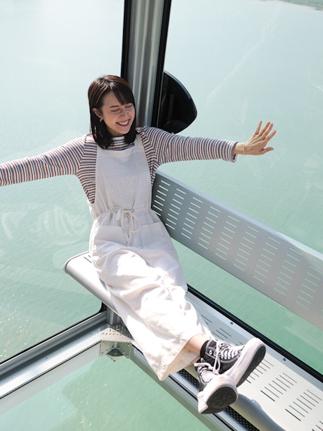 Person enjoying a ride in the Ngong Ping Cable Car over water in Hong Kong.