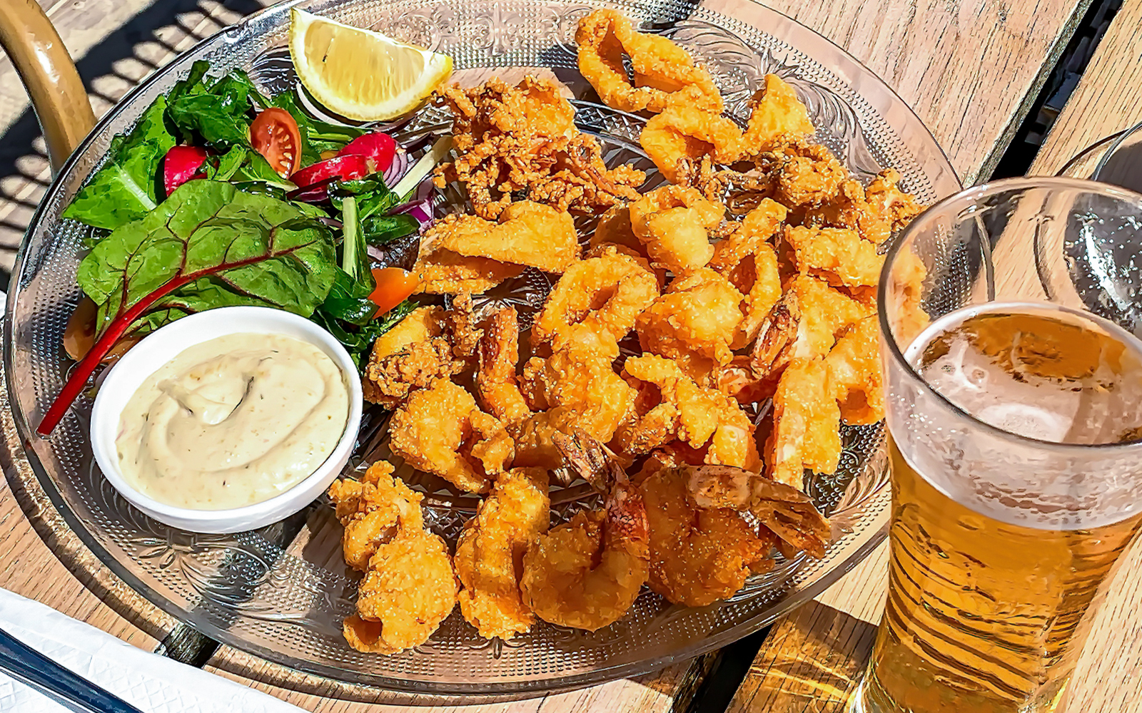 Crispy calamari and beer served at an outdoor cafe table