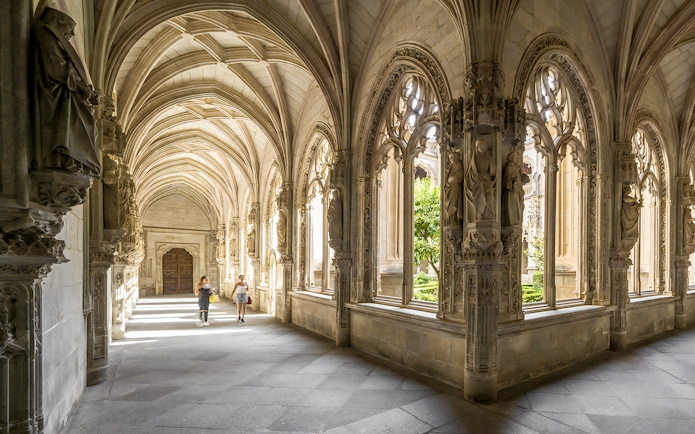 Gothic cloister with ornate arches in Toledo, Spain, during a guided tour from Madrid.