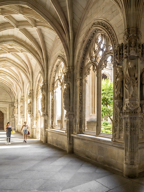 Gothic cloister with ornate arches in Toledo, Spain, during a guided tour from Madrid.