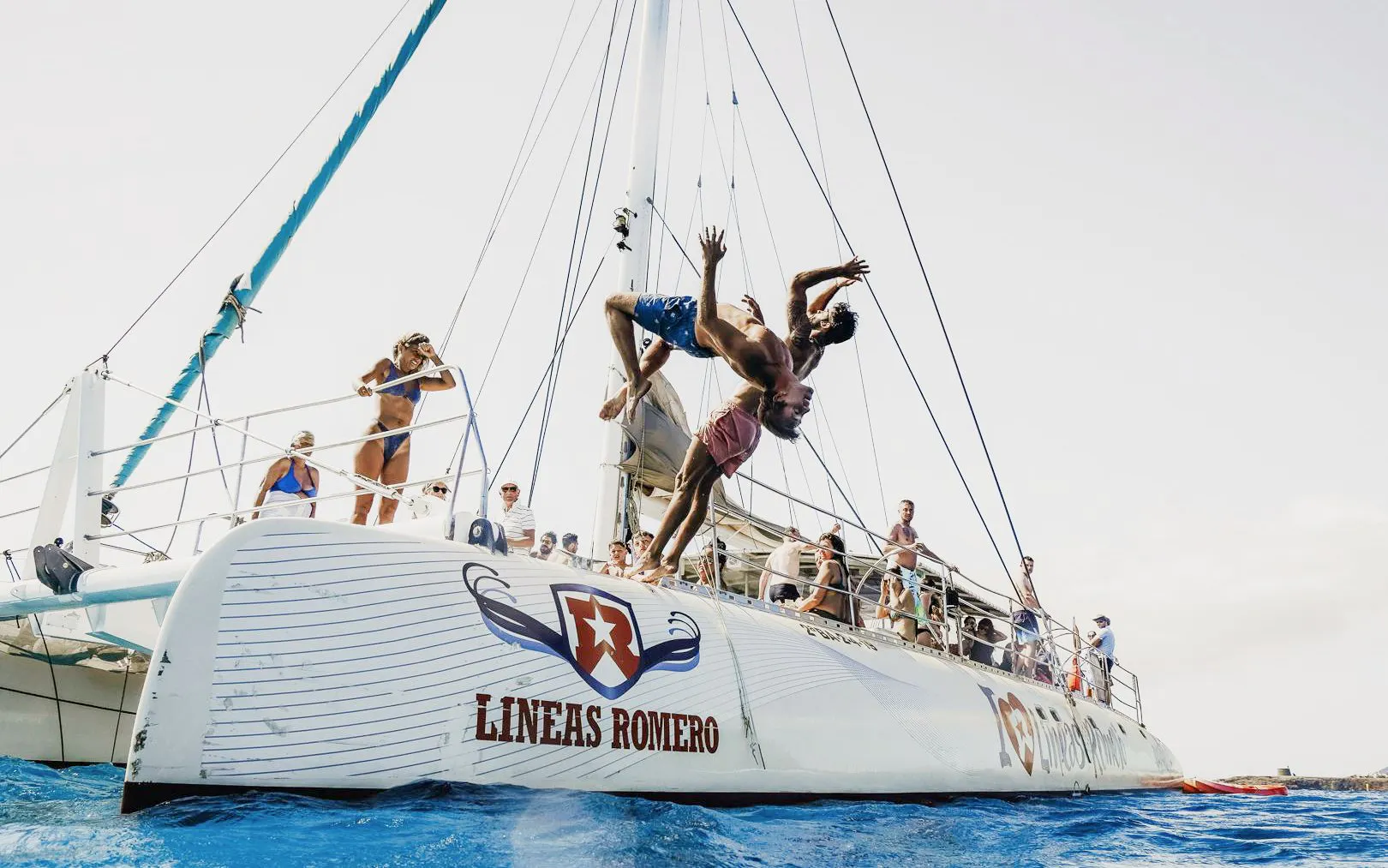 People diving off a catamaran during a mini cruise to Papagayo Beaches, Lanzarote.