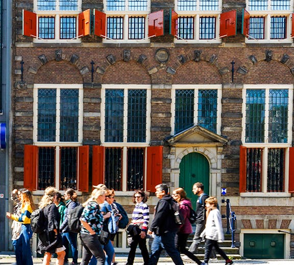 Rembrandt House Museum facade with visitors walking, Amsterdam.