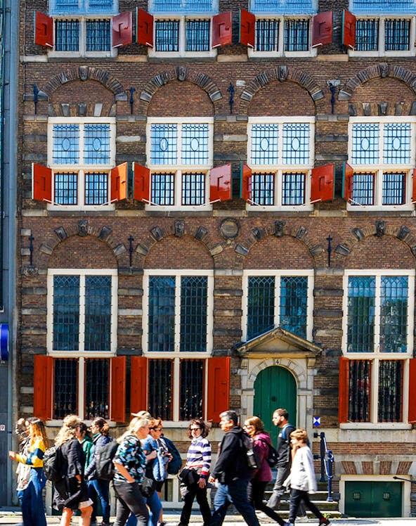 Rembrandt House Museum facade with visitors walking, Amsterdam.