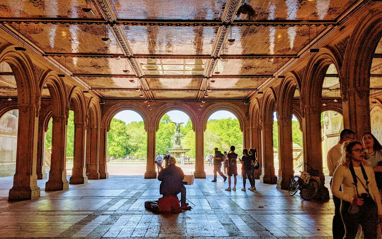 Bethesda Terrace arches with people and Bethesda Fountain in Central Park, New York.
