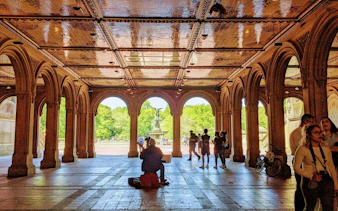 Bethesda Terrace arches with people and Bethesda Fountain in Central Park, New York.