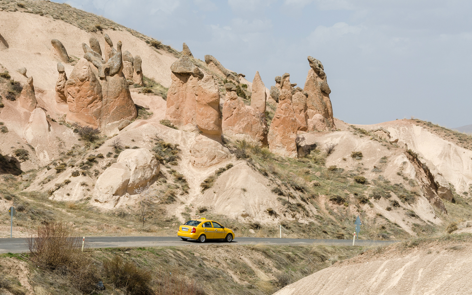 Taxi driving through Cappadocia's unique rock formations.