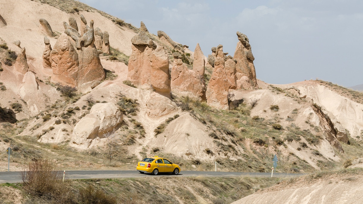 Taxi driving through Cappadocia's unique rock formations.