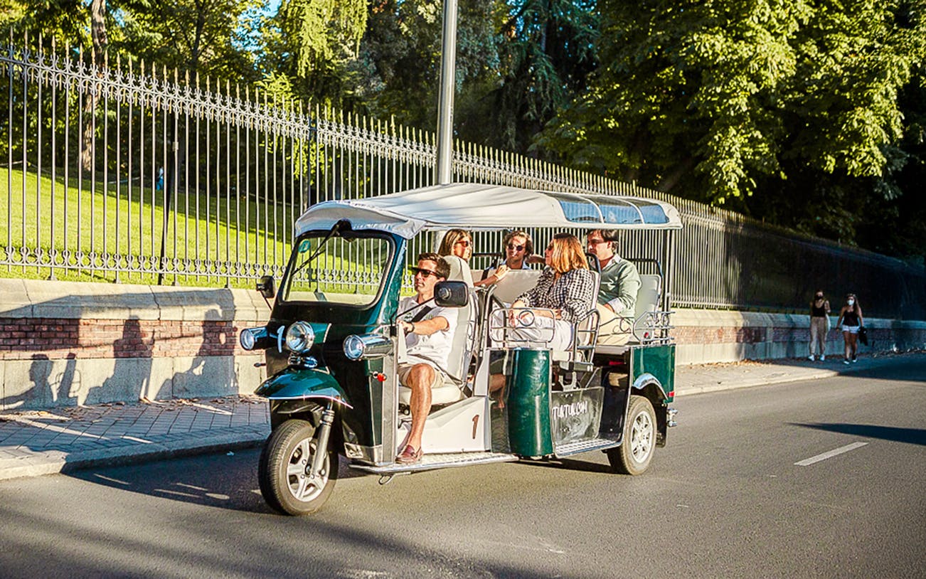 Tuk Tuk driving through Madrid's historic streets, showcasing iconic landmarks on a private eco-friendly tour.