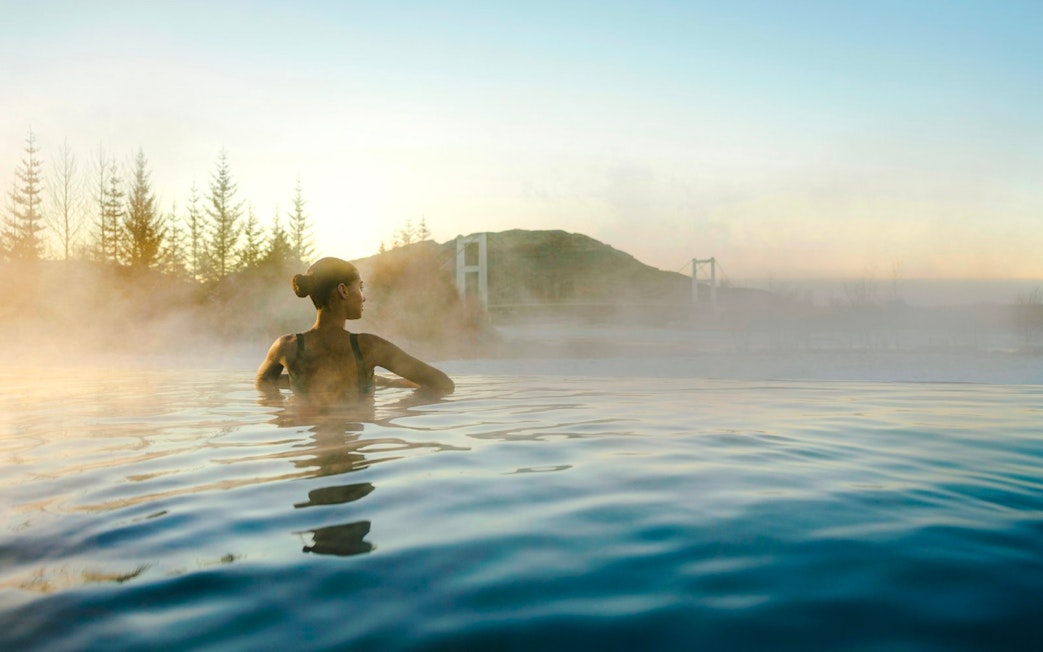 Guests enjoying the warm waters of Laugarás Lagoon's infinity pool.