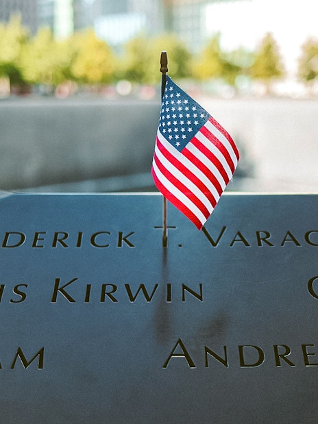 #Names engraved at 9/11 Memorial with small American flag, New York City.