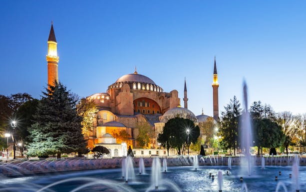 Hagia Sophia at dusk with illuminated minarets and fountain, Istanbul.
