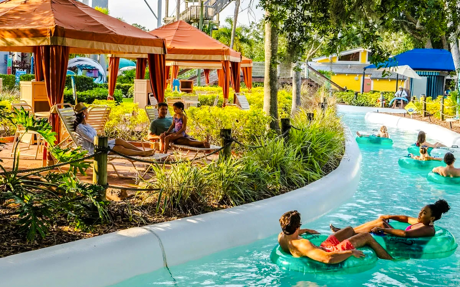 Visitors relaxing in cabanas and floating on a lazy river at Adventure Island, Florida.