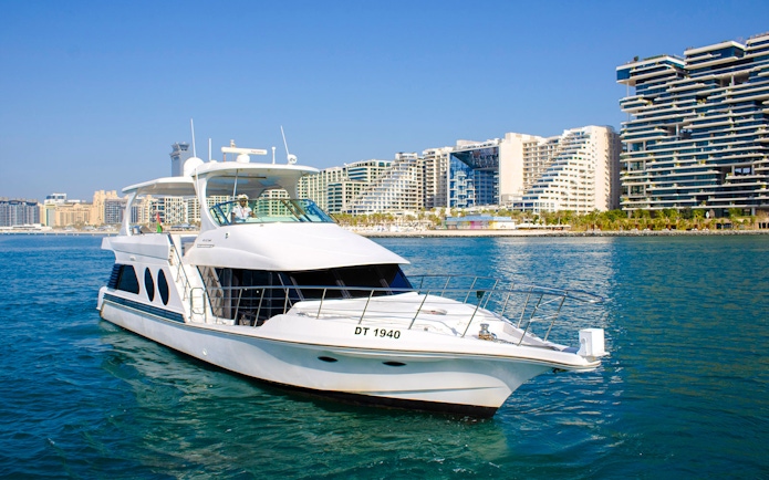 Luxury yacht cruising near Dubai's modern skyline.