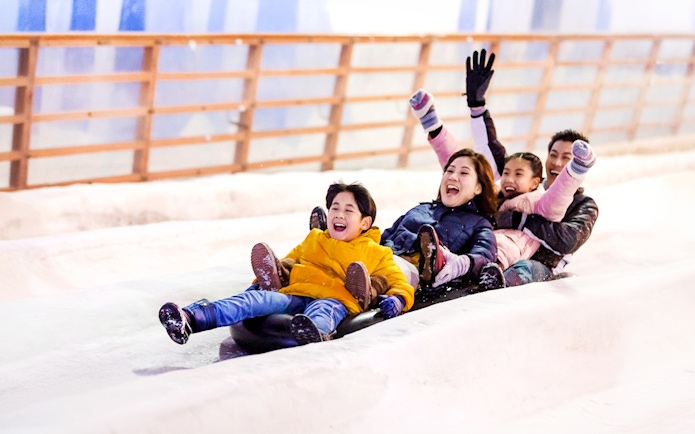 Guests sledding inside Singapore Snow City.