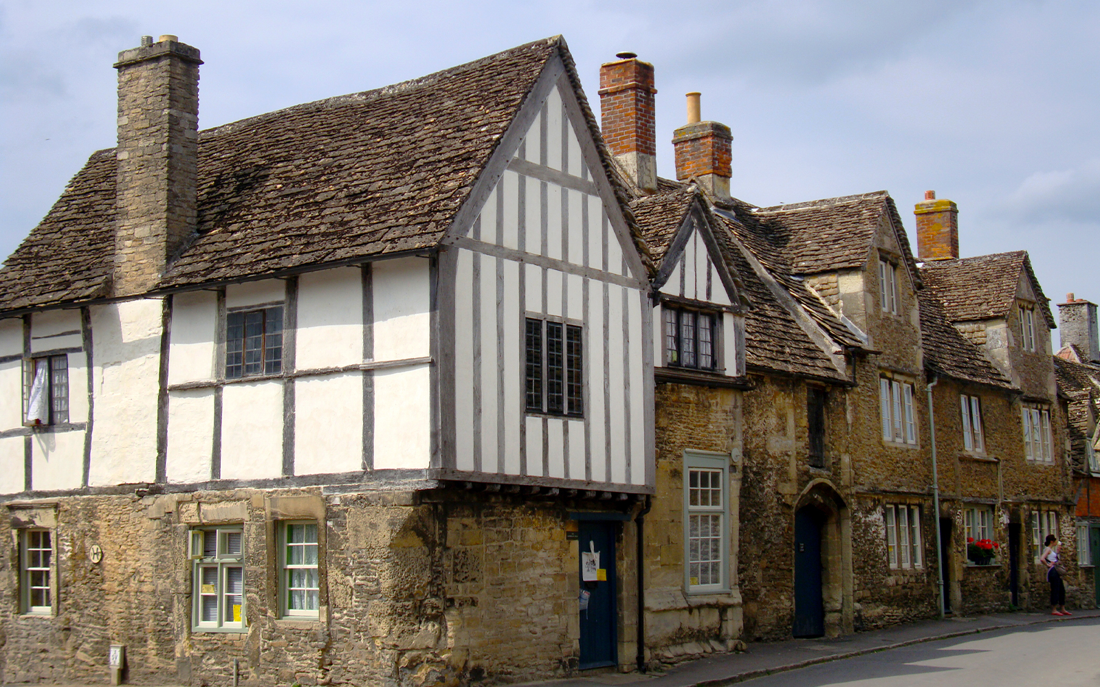 Historic stone cottages in Lacock village, Wiltshire, with timber-framed facades.