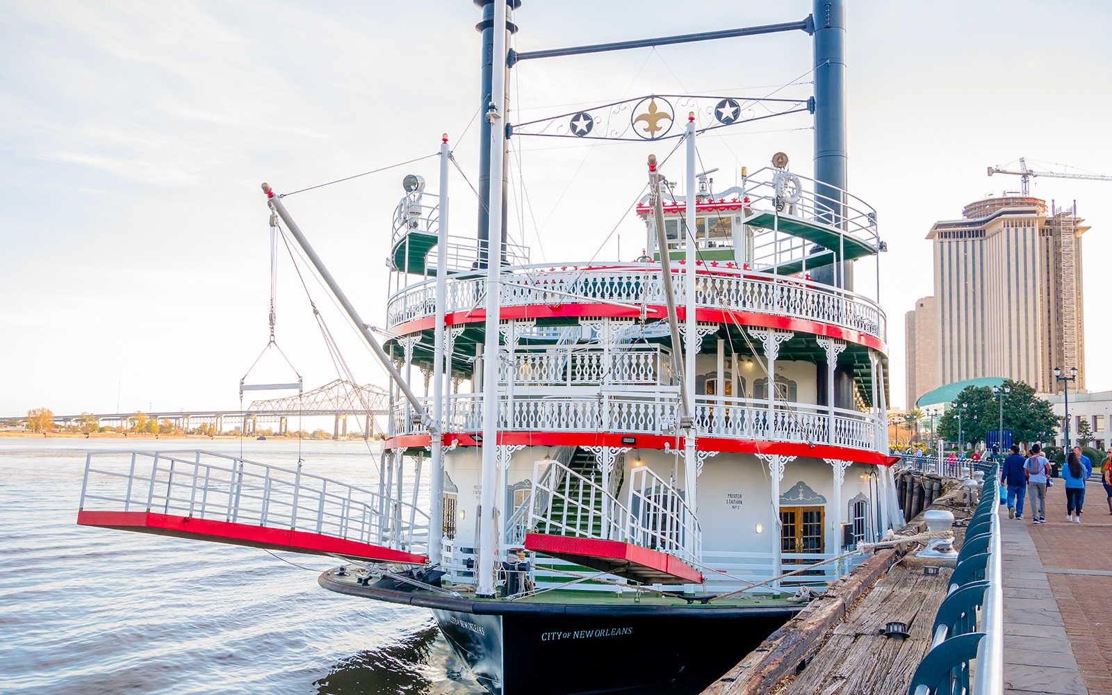 New Orleans paddle steamer cruising the Mississippi River with city skyline in the background.