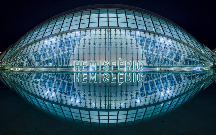 Hemisfèric building illuminated at night, Valencia, Spain.