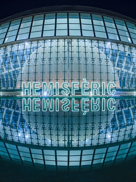 Hemisfèric building illuminated at night, Valencia, Spain.