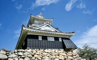Hamamatsu Castle in Japan with traditional architecture under a clear blue sky.