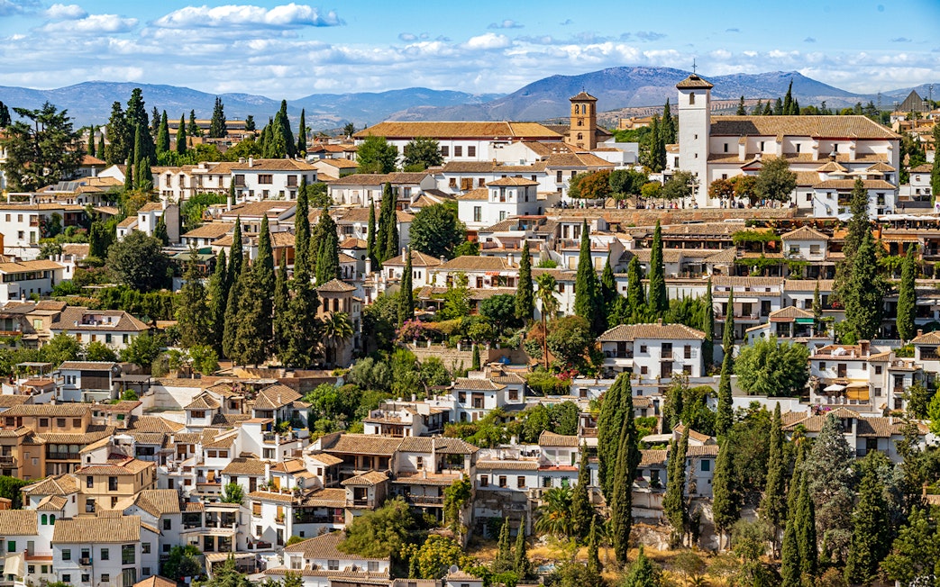 Granada's Albaicín district with whitewashed buildings and cypress trees, view from Alhambra.