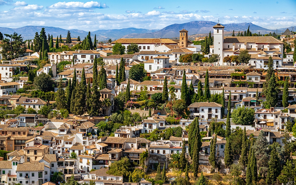 Granada's Albaicín district with whitewashed buildings and cypress trees, view from Alhambra.