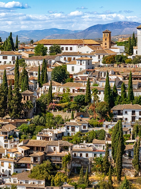 Granada's Albaicín district with whitewashed buildings and cypress trees, view from Alhambra.