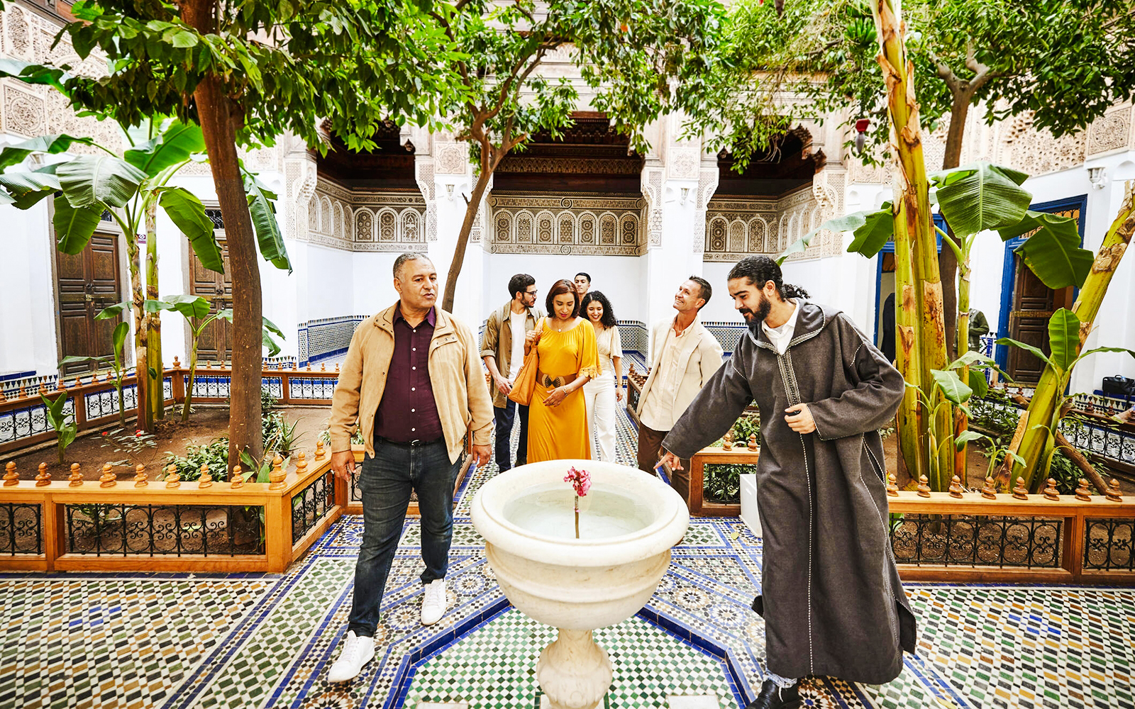 Tourists with a guide in the courtyard of Bahia Palace, Marrakech, Morocco.