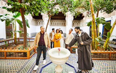 Tourists with a guide in the courtyard of Bahia Palace, Marrakech, Morocco.