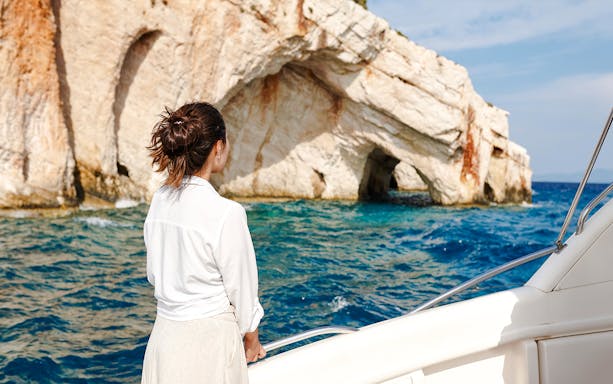 Woman on boat viewing Blue Caves in Zakynthos, Greece.