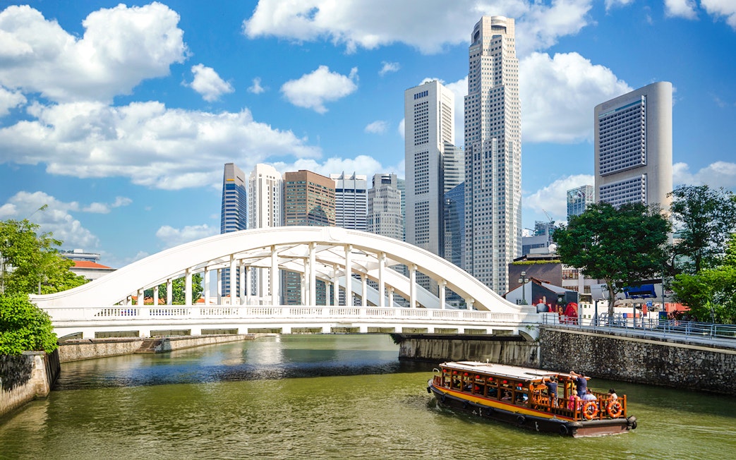 Elgin Bridge over Singapore River with cruise boat and city skyline.