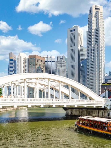 Elgin Bridge over Singapore River with cruise boat and city skyline.