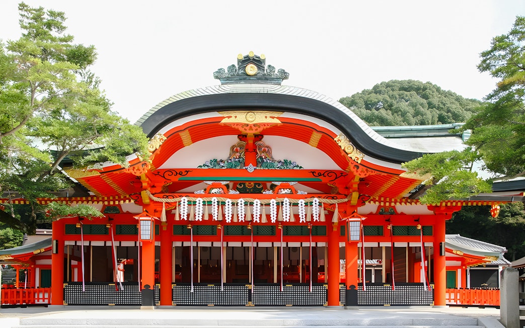 Fushimi Inari Taisha Shrine entrance with vibrant red and white architecture, Kyoto.