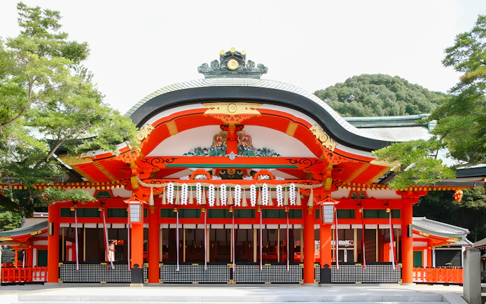 Fushimi Inari Taisha Shrine entrance with vibrant red and white architecture, Kyoto.