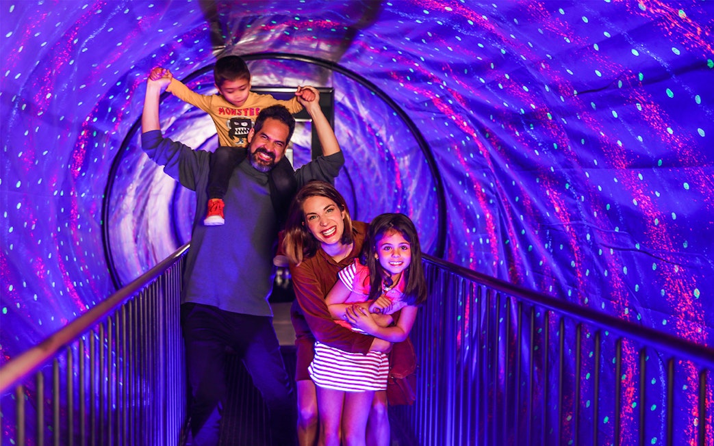 Family enjoying the vortex tunnel at the Museum of Illusions.