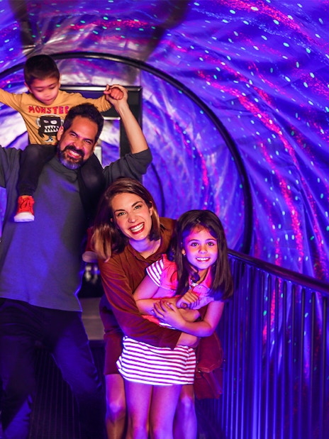 Family enjoying the vortex tunnel at the Museum of Illusions.