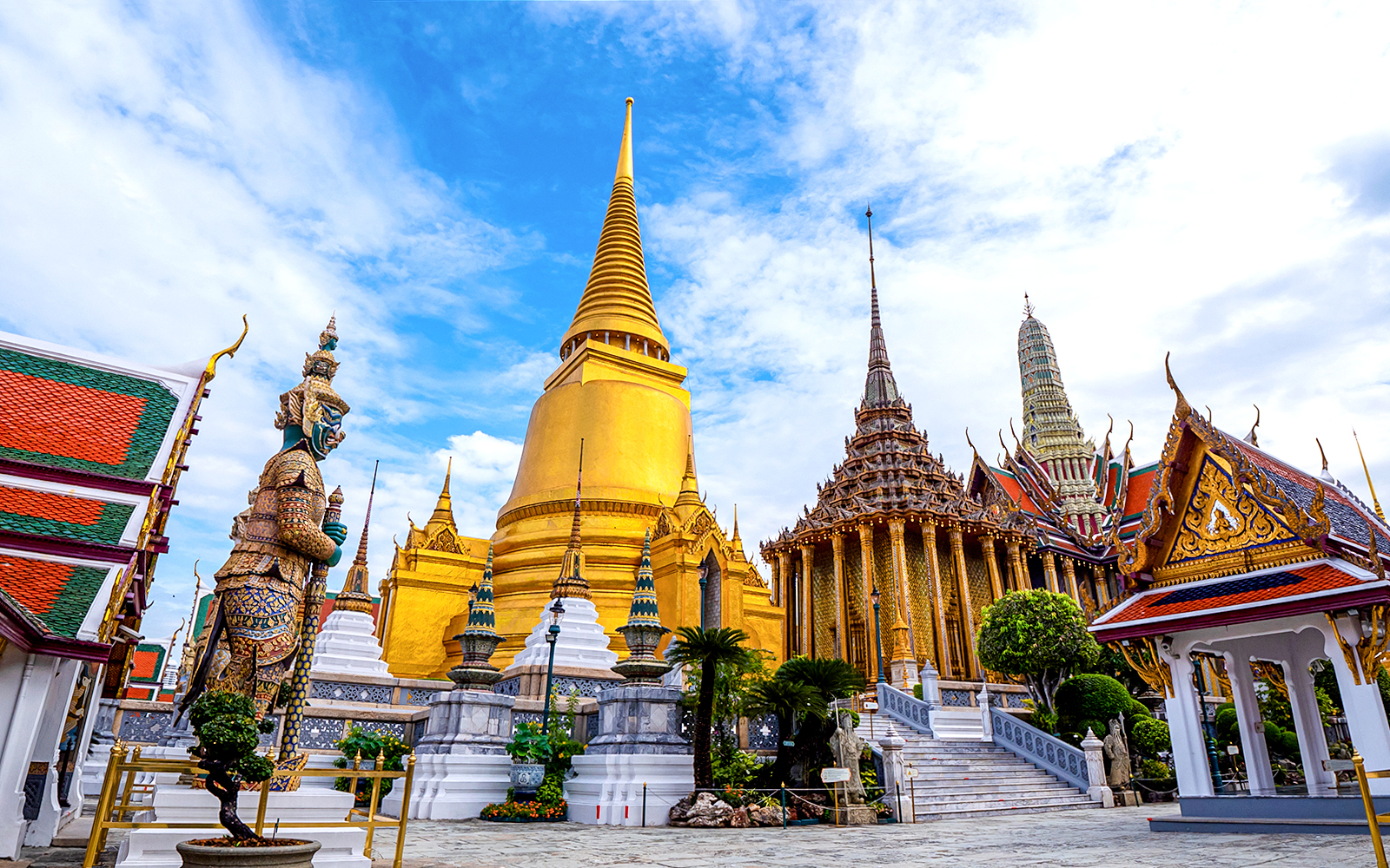 Wat Phra Kaew and Grand Palace with golden spires and ornate statues, Bangkok, Thailand.