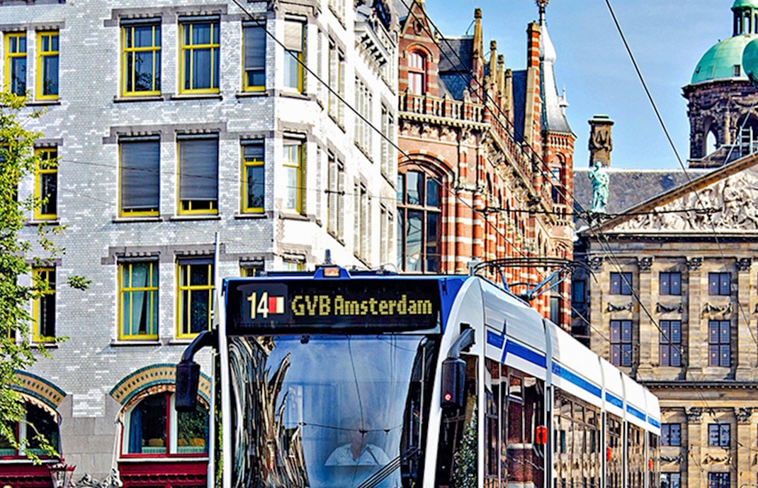 Tram 14 in Amsterdam city center near historic buildings, part of GVB Public Transport Pass.