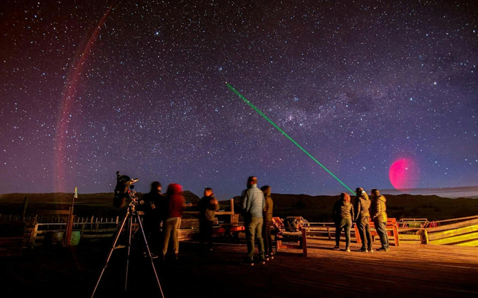 Stargazing group with telescope under starry sky in Calafate.