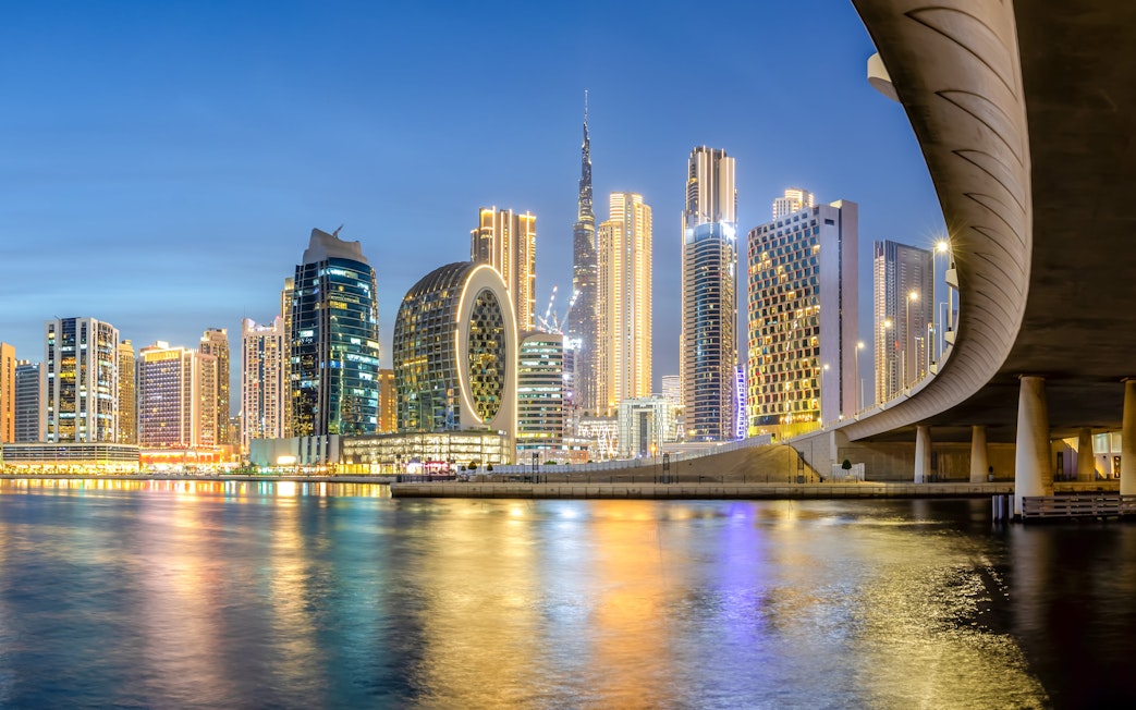 Dubai Canal with illuminated skyline and modern architecture at night.