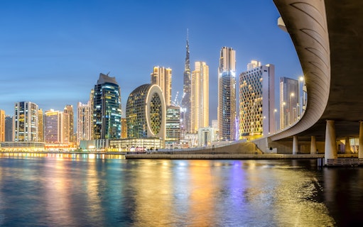 Dubai Canal with illuminated skyline and modern architecture at night.