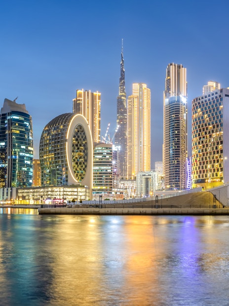 Dubai Canal with illuminated skyline and modern architecture at night.