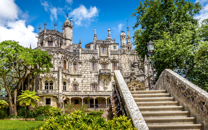 Quinta da Regaleira front view with ornate architecture and stone staircase in Sintra, Portugal.