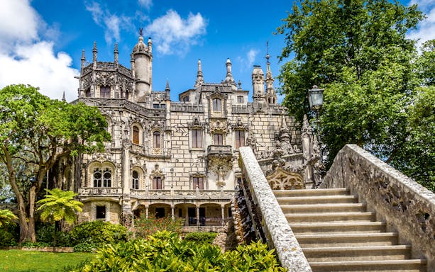Quinta da Regaleira front view with ornate architecture and stone staircase in Sintra, Portugal.