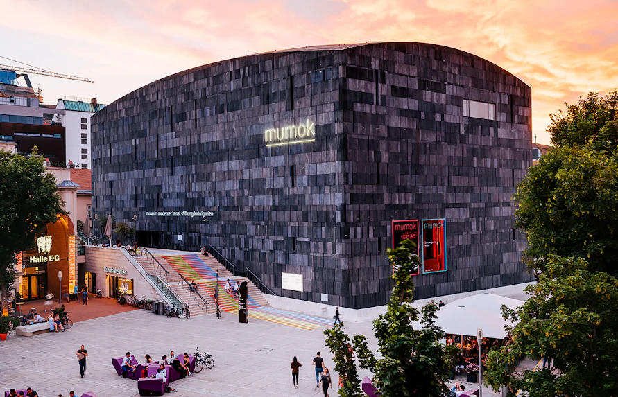 Mumok Museum in Vienna with colorful steps and people in the plaza.