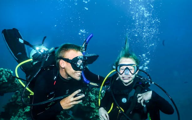 Scuba diving lesson for beginners in Maui with instructor and student underwater.