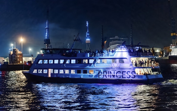 Large ship illuminated at night during 1.5h Grand Evening Lights Cruise.