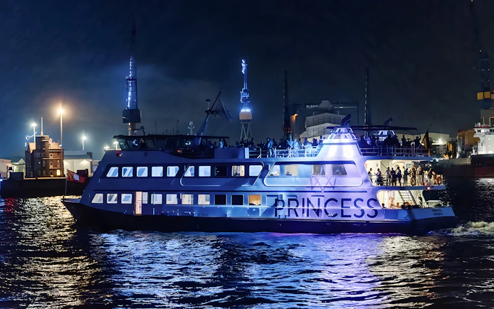 Large ship illuminated at night during 1.5h Grand Evening Lights Cruise.