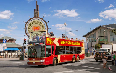 Big Bus San Francisco tour at Fisherman's Wharf with passengers on the open-top deck.
