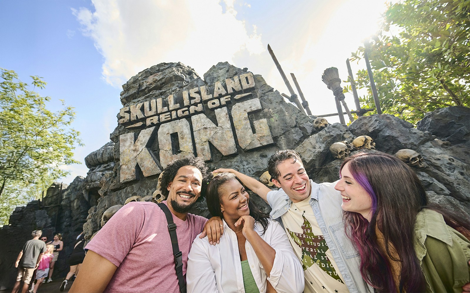 Guests smiling in front of Skull Island: Reign of Kong entrance at Universal Studios Orlando.
