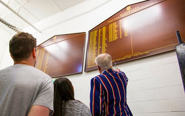 Guide explaining cricket history at Melbourne Cricket Ground tour.